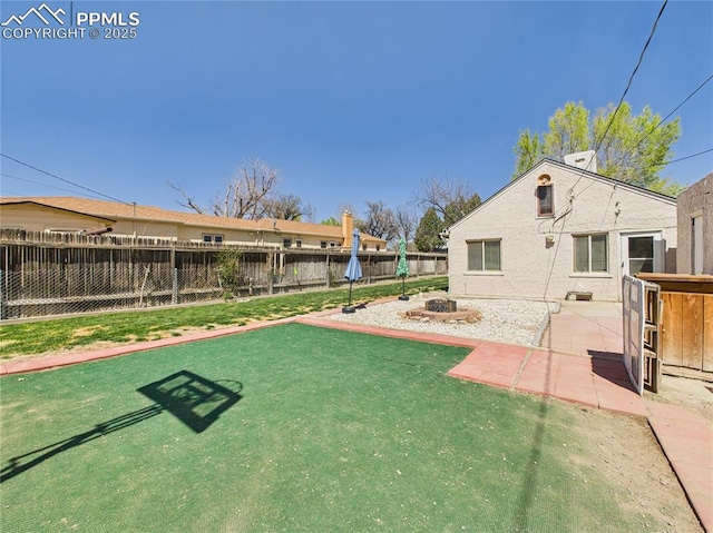 view of yard featuring a patio, a fire pit, and a fenced backyard
