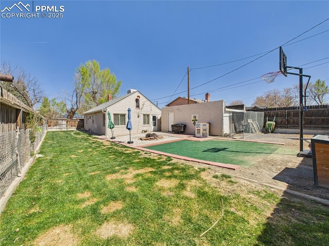rear view of property featuring a fenced backyard and a lawn