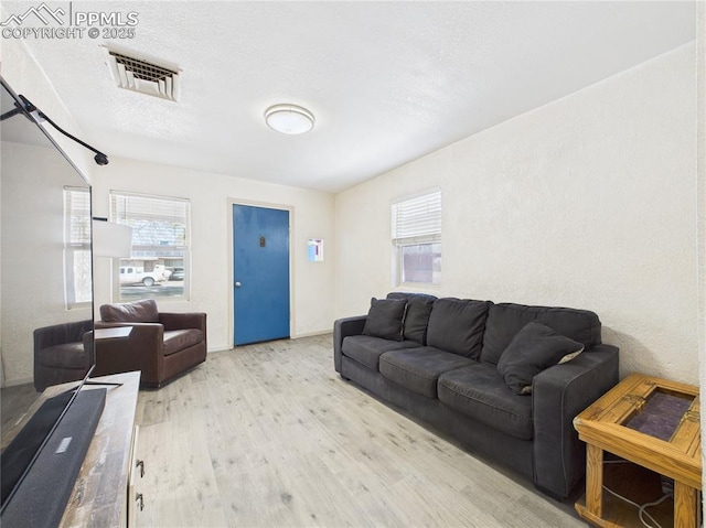 living room with visible vents and wood finished floors