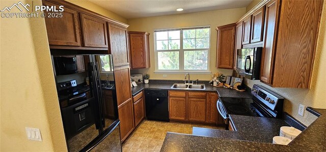 kitchen with a sink, black appliances, and brown cabinets