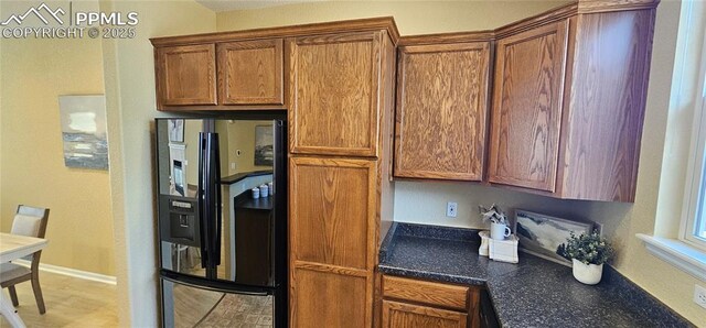 kitchen featuring brown cabinetry and black fridge
