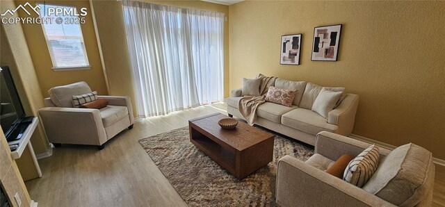 living area featuring a textured wall and wood finished floors