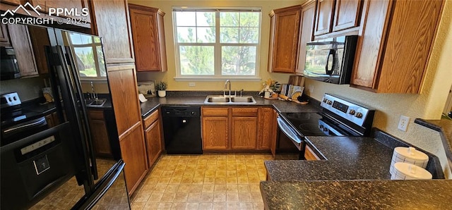 kitchen featuring brown cabinets, a sink, black appliances, and dark countertops