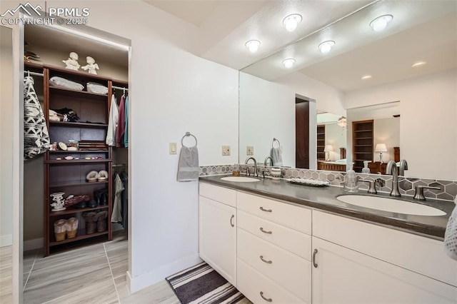 440 Scrub Oak Cir, Monument, CO 80132 - bathroom featuring double vanity, a walk in closet, and baseboards