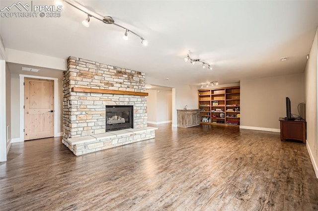 440 Scrub Oak Cir, Monument, CO 80132 - unfurnished living room with track lighting, baseboards, a stone fireplace, and wood finished floors