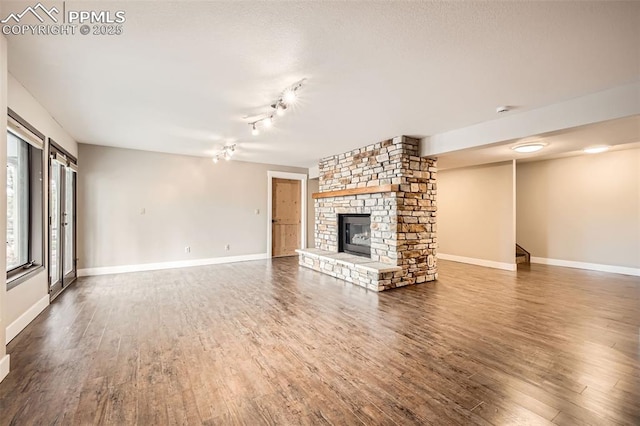 440 Scrub Oak Cir, Monument, CO 80132 - unfurnished living room featuring wood finished floors, a large fireplace, and baseboards