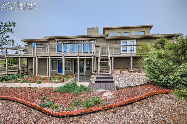 440 Scrub Oak Cir, Monument, CO 80132 - back of property with a wooden deck, stairs, and a chimney