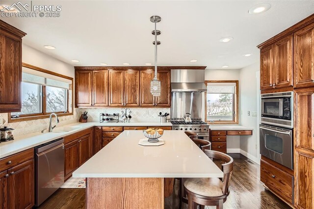 440 Scrub Oak Cir, Monument, CO 80132 - kitchen with appliances with stainless steel finishes, wall chimney range hood, a sink, healthy amount of natural light, and recessed lighting