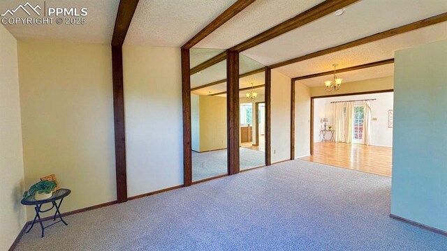 5125 Thistle Ct, Colorado Springs, CO 80917 - carpeted spare room featuring beamed ceiling, a chandelier, and baseboards