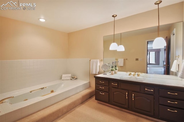 bathroom with a tub with jets and vanity