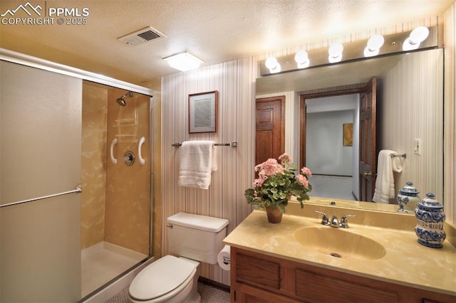 full bath featuring a textured ceiling, visible vents, a shower stall, vanity, and toilet