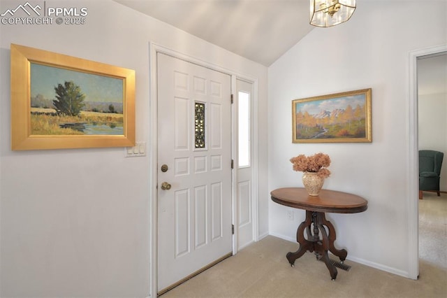 carpeted foyer entrance featuring baseboards, an inviting chandelier, and lofted ceiling