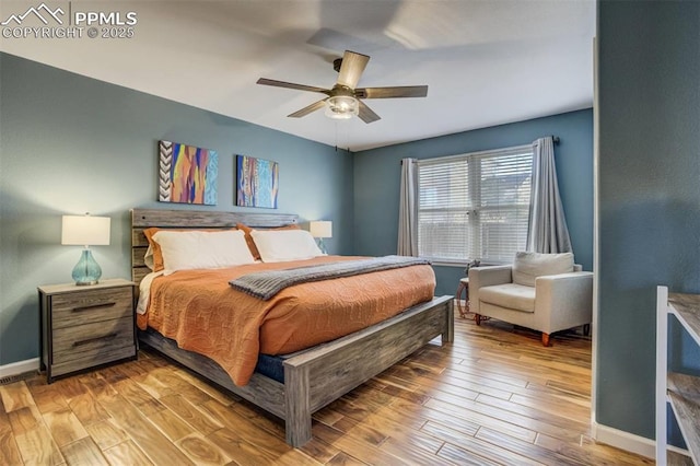 bedroom with wood finished floors, a ceiling fan, and baseboards