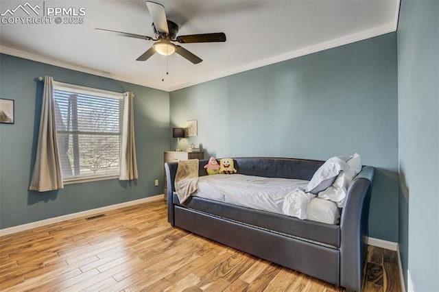 bedroom featuring baseboards, ornamental molding, wood finished floors, and visible vents