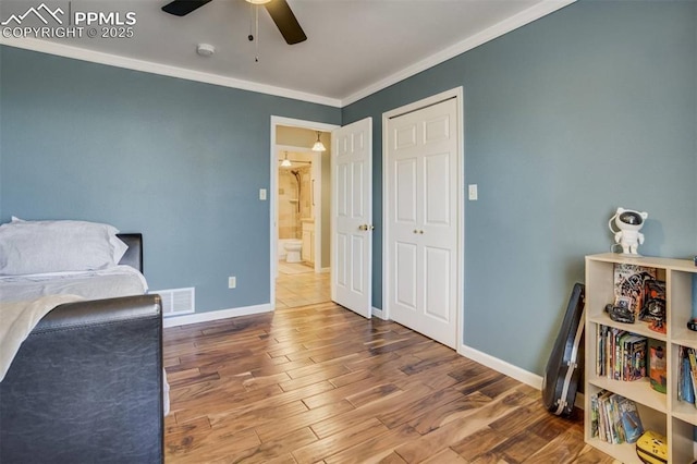 office space featuring wood finished floors, visible vents, ornamental molding, baseboards, and ceiling fan