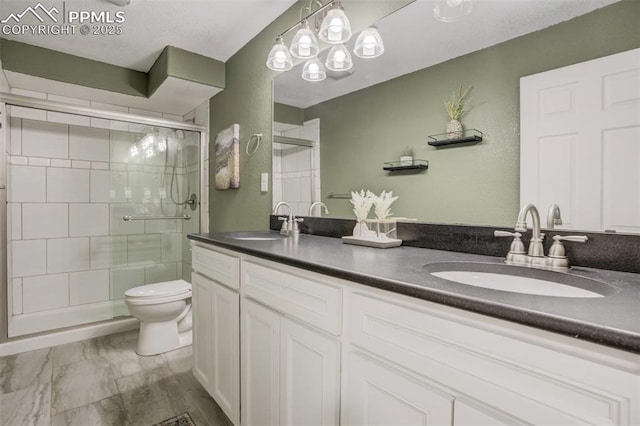 full bath with toilet, a sink, double vanity, and a stall shower