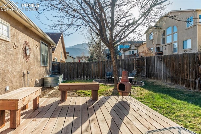 deck featuring a fenced backyard, a mountain view, and a residential view