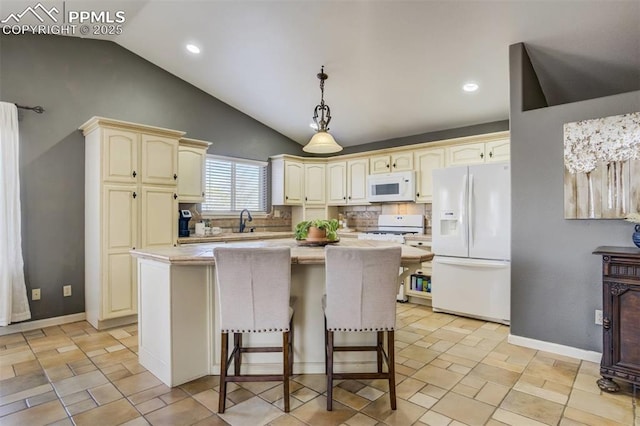 kitchen featuring a center island, a sink, white appliances, light countertops, and cream cabinets