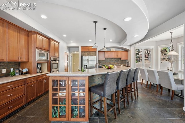 kitchen featuring tasteful backsplash, recessed lighting, light countertops, and stainless steel appliances