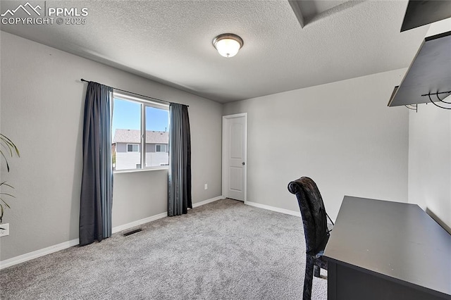 unfurnished office with a textured ceiling, carpet floors, visible vents, and baseboards
