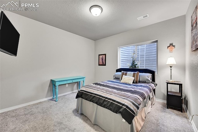 bedroom with carpet floors, a textured ceiling, visible vents, and baseboards