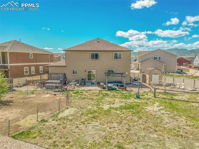 back of property featuring a storage shed, a patio area, a fenced backyard, and stucco siding