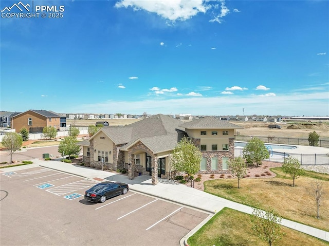view of property with fence and uncovered parking