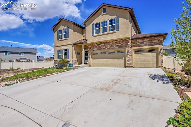 view of front of house featuring driveway, stone siding, fence, a garage, and stucco siding