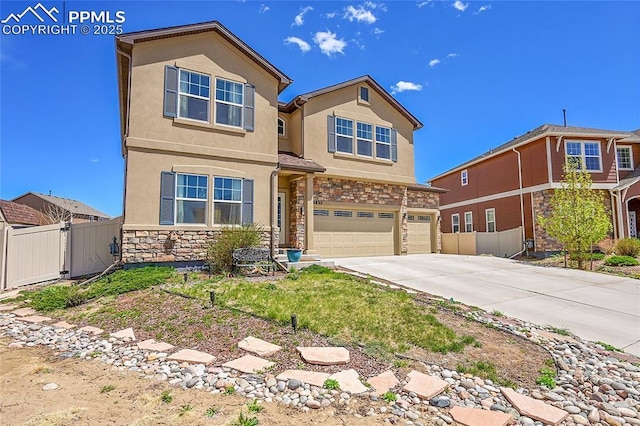 traditional-style home featuring driveway, stone siding, fence, a garage, and stucco siding