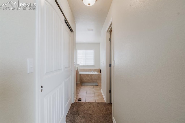 6117 Hayfield Pl, Colorado Springs, CO 80925 - corridor with light colored carpet, light tile patterned flooring, and visible vents