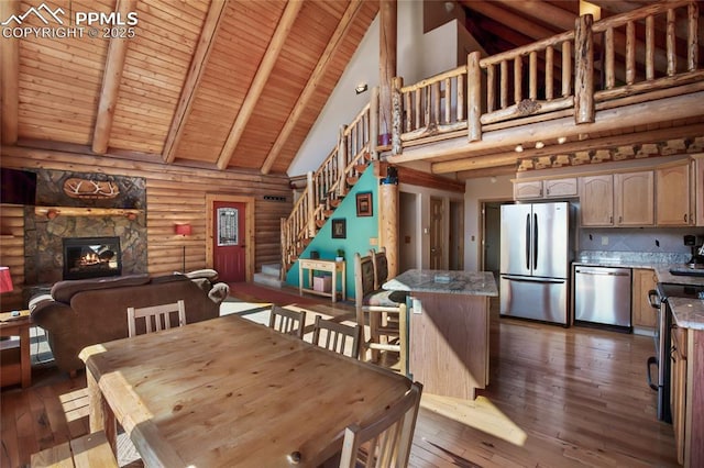 876 Obsidian Dr, Florissant, CO 80816 - dining space featuring beam ceiling, stairway, high vaulted ceiling, wood-type flooring, and log walls