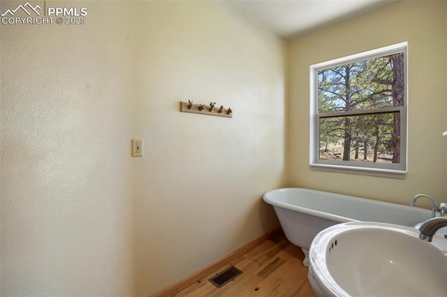 616 Moffat Dr, Cripple Creek, CO 80813 - bathroom featuring a soaking tub, visible vents, and wood finished floors