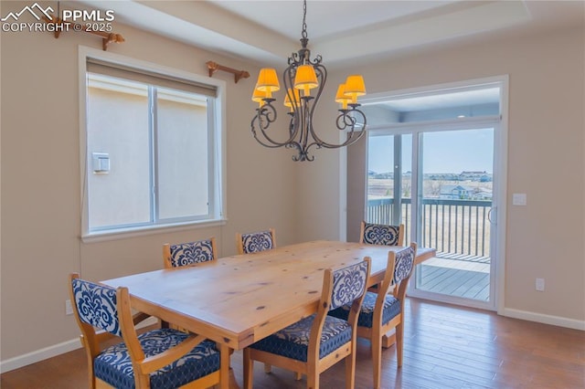 1474 Promontory Bluff Vw, Colorado Springs, CO 80921 - dining space featuring a chandelier, baseboards, wood finished floors, and a water view