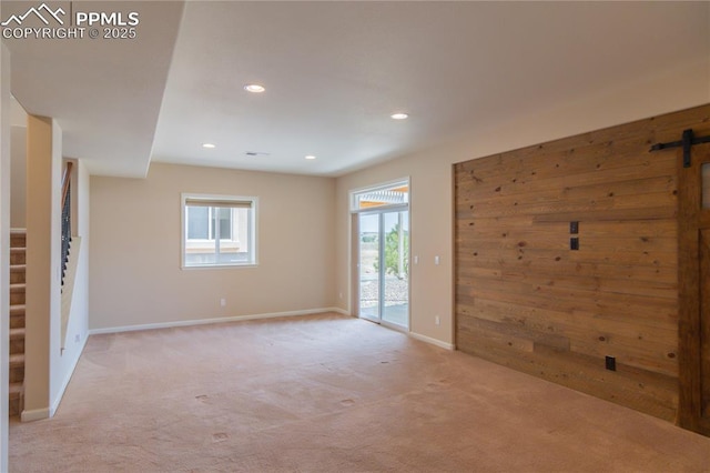 1474 Promontory Bluff Vw, Colorado Springs, CO 80921 - unfurnished room with a barn door, light colored carpet, recessed lighting, and baseboards