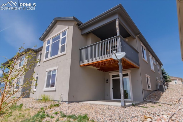 1474 Promontory Bluff Vw, Colorado Springs, CO 80921 - rear view of house with stucco siding, a patio, a balcony, and cooling unit