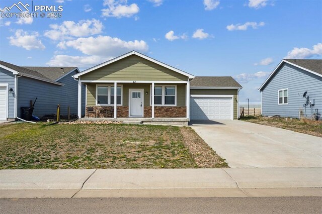 view of front of house featuring an attached garage, driveway, a porch, and stone siding
