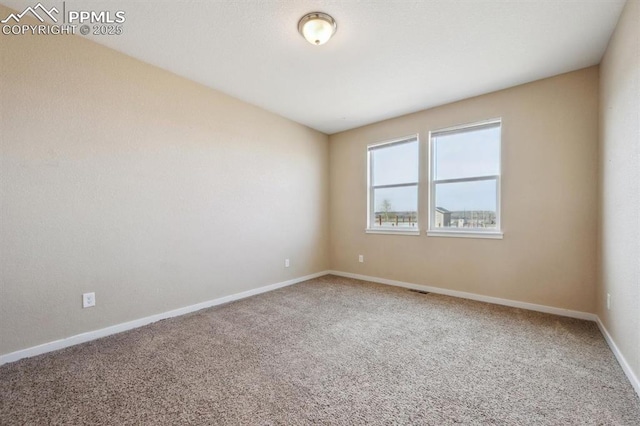 carpeted empty room with baseboards