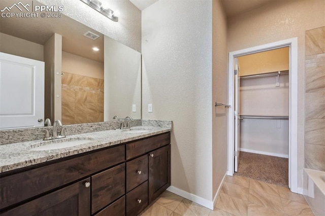 full bathroom with a textured wall, visible vents, a shower, and a sink