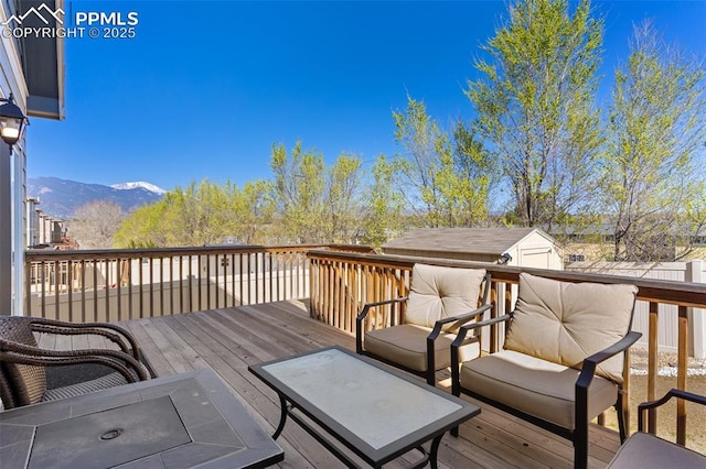 1185 Antrim Loop, Colorado Springs, CO 80910 - wooden terrace with an outdoor living space, a mountain view, and an outdoor structure