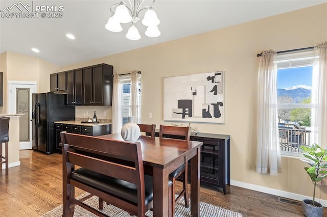 1185 Antrim Loop, Colorado Springs, CO 80910 - dining room featuring visible vents, light wood finished floors, a notable chandelier, and a healthy amount of sunlight