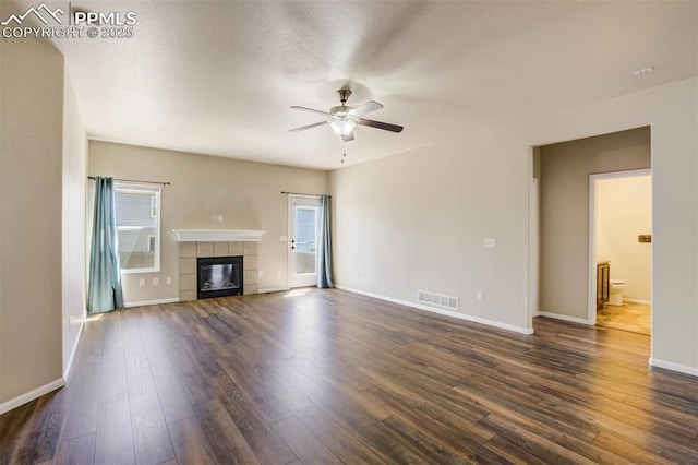7935 Morning Dew Rd, Colorado Springs, CO 80908 - unfurnished living room featuring a tile fireplace, a ceiling fan, visible vents, and plenty of natural light