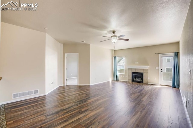 7935 Morning Dew Rd, Colorado Springs, CO 80908 - unfurnished living room featuring visible vents, baseboards, ceiling fan, a fireplace, and dark wood-type flooring