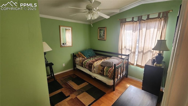 bedroom featuring multiple windows, crown molding, baseboards, wood finished floors, and vaulted ceiling