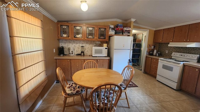 kitchen with white appliances, vaulted ceiling, exhaust hood, backsplash, and light tile patterned floors