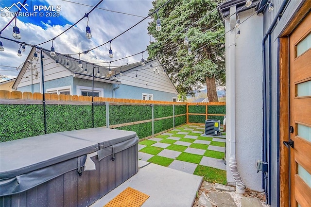 view of patio / terrace featuring a fenced backyard, a hot tub, and cooling unit