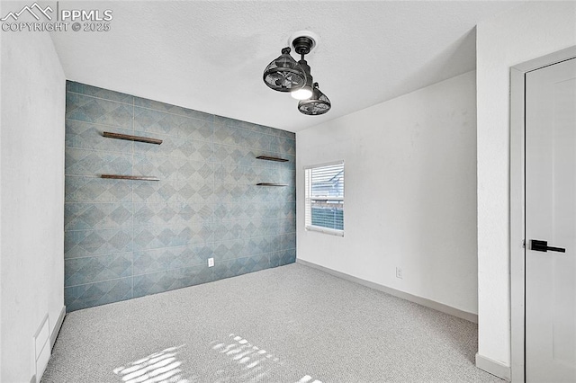 carpeted spare room featuring baseboards