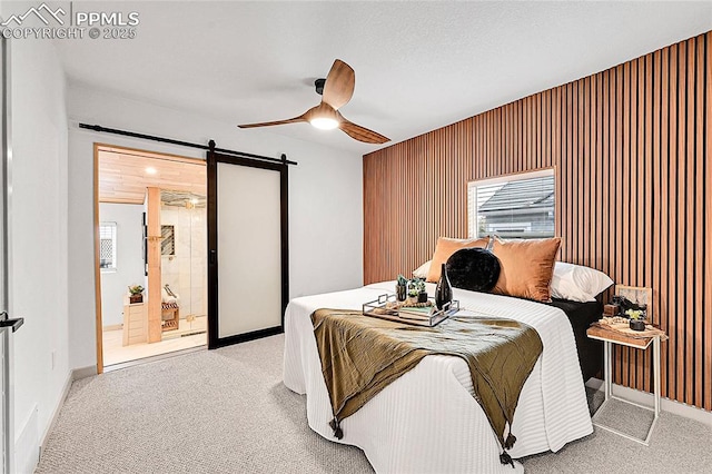 bedroom with a ceiling fan, baseboards, light colored carpet, and a barn door