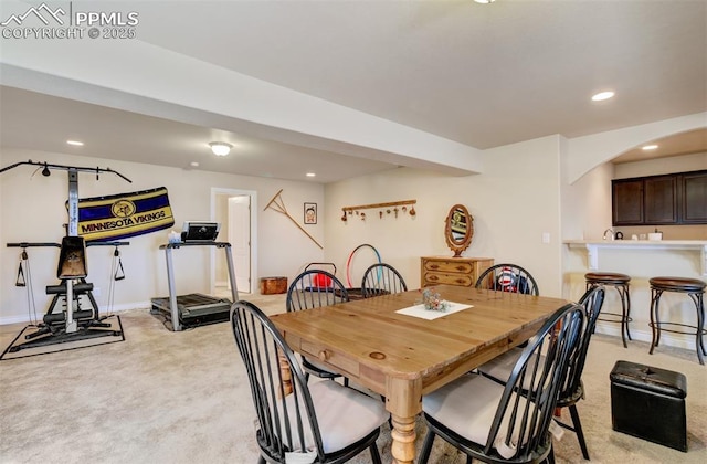 9825 Golf Crest Dr, Peyton, CO 80831 - dining space with baseboards, recessed lighting, arched walkways, and light carpet