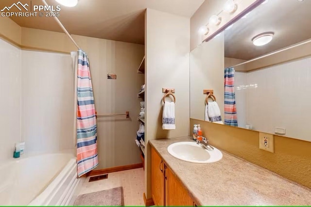 bathroom with visible vents, shower / bath combo with shower curtain, and vanity