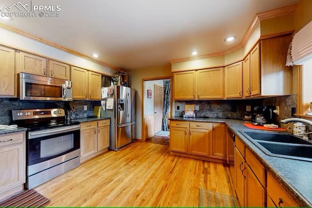 kitchen featuring stainless steel appliances, decorative backsplash, a sink, and dark countertops